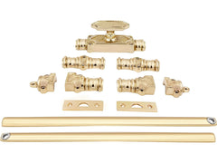 A set of polished brass espagnolette bolt components, including a latch, lock, hinges, brackets, and two long rails.